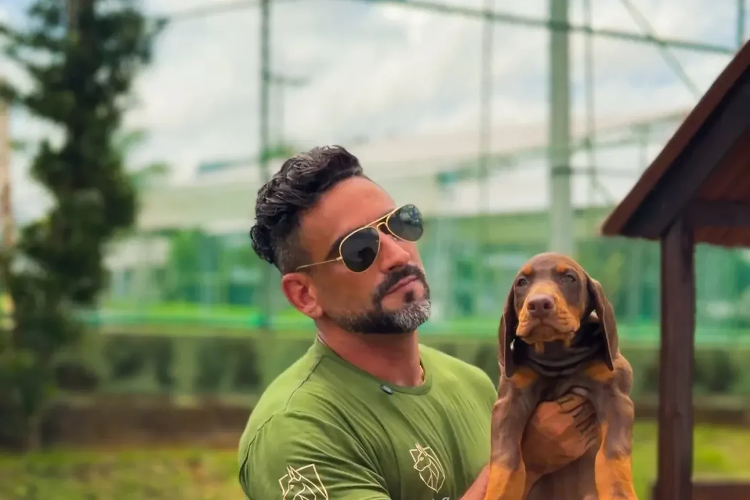 Criador Marcelo Vaz segurando e mostrando um filhote de Doberman no canil Dobs Kennel