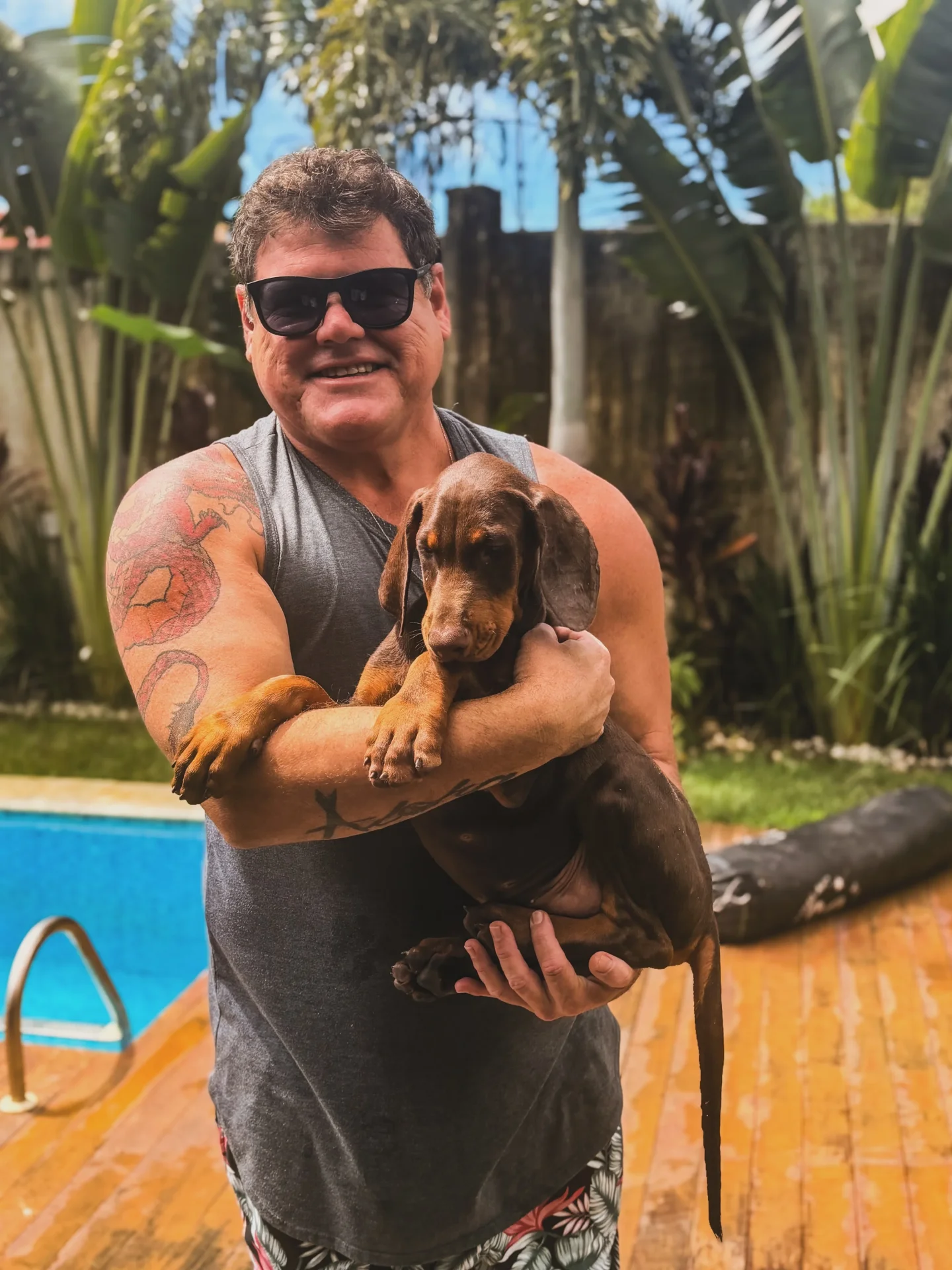 Cliente segurando no colo o filhote de Doberman marrom no dia da entrega